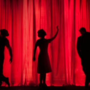 silhouette of three performers on stage