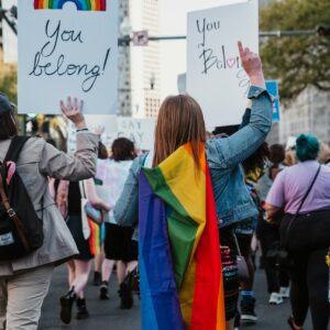 a group of people walking down a street holding signs