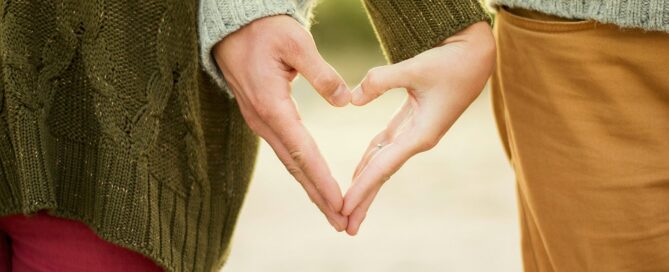 person forming heart shape with their hands